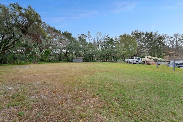2812 Tom Brewer Ln, Plant City, FL 33566 - view of green lawn with a storage unit and view of wooded area