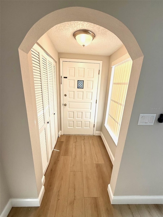 7314 Ivanhoe Dr, Port Richey, FL 34668 - entrance foyer featuring arched walkways, light wood-type flooring, and a textured ceiling