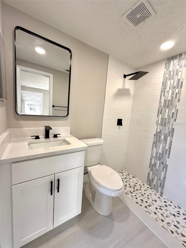 7314 Ivanhoe Dr, Port Richey, FL 34668 - bathroom featuring tiled shower, vanity, a textured ceiling, and recessed lighting
