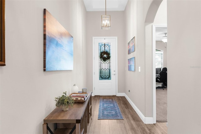 11597 Weaver Hollow Rd, New Port Richey, FL 34654 - foyer featuring arched walkways, wood finished floors, plenty of natural light, and a chandelier