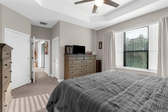11597 Weaver Hollow Rd, New Port Richey, FL 34654 - bedroom featuring light colored carpet, a tray ceiling, and ceiling fan