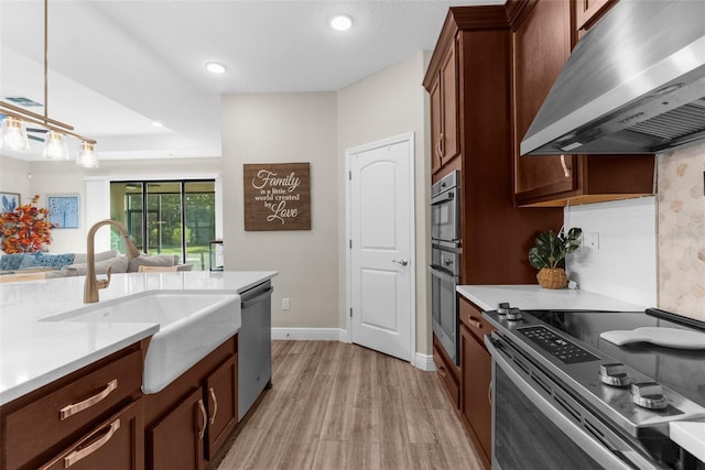 11597 Weaver Hollow Rd, New Port Richey, FL 34654 - kitchen featuring ventilation hood, stainless steel appliances, light wood-style floors, light countertops, and recessed lighting