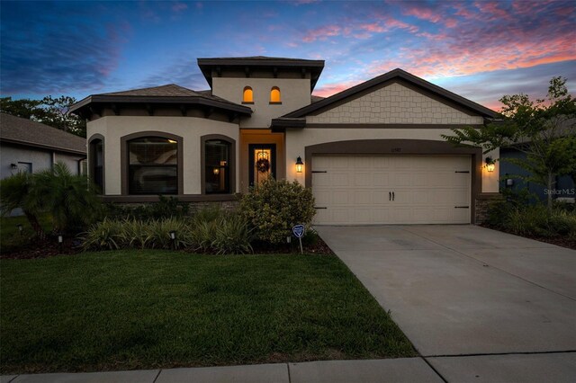 11597 Weaver Hollow Rd, New Port Richey, FL 34654 - mediterranean / spanish-style house featuring a garage, concrete driveway, a front lawn, stucco siding, and stone siding