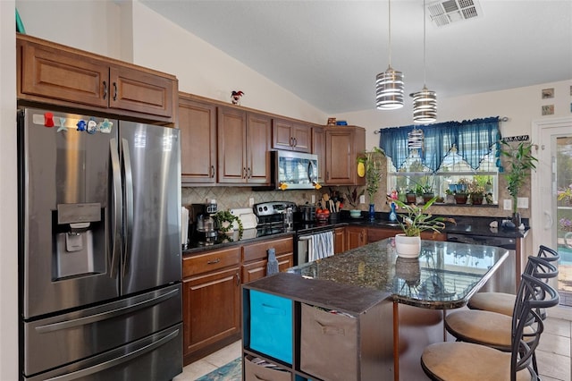 3243 Azalea Dr, Hernando Beach, FL 34607 - kitchen with stainless steel appliances, backsplash, a kitchen bar, vaulted ceiling, and dark stone countertops