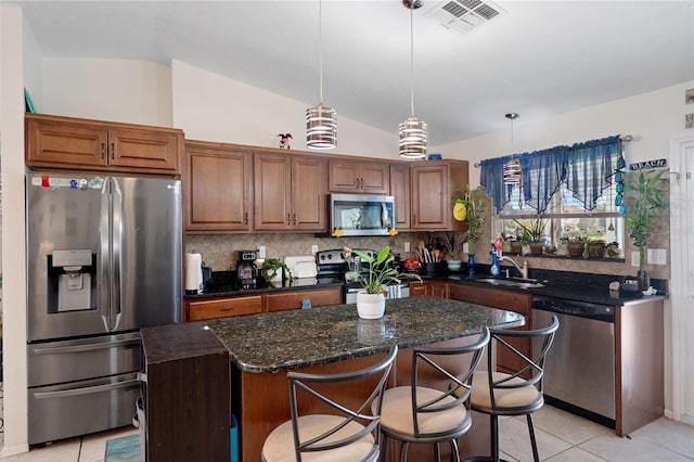 3243 Azalea Dr, Hernando Beach, FL 34607 - kitchen with appliances with stainless steel finishes, decorative backsplash, a center island, light tile patterned flooring, and lofted ceiling