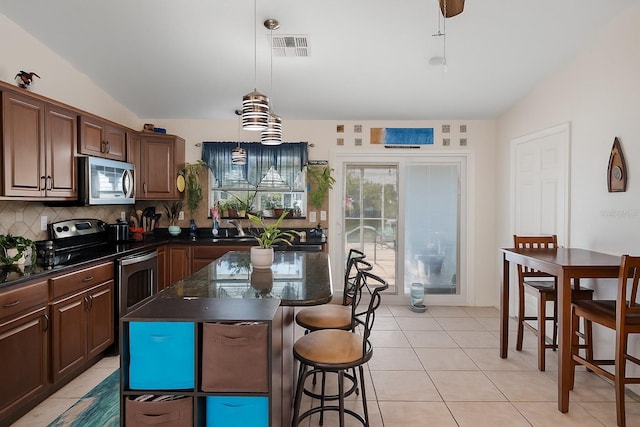 3243 Azalea Dr, Hernando Beach, FL 34607 - kitchen featuring stainless steel appliances, decorative backsplash, a breakfast bar area, a kitchen island, and decorative light fixtures