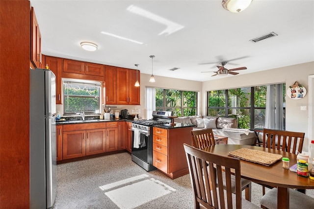 3622 W Mullen Ave, Tampa, FL 33609 - kitchen featuring stainless steel appliances, a ceiling fan, a peninsula, brown cabinets, and hanging light fixtures