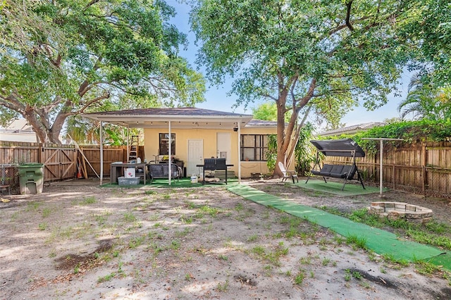 3622 W Mullen Ave, Tampa, FL 33609 - back of property featuring an outdoor fire pit, a fenced backyard, a patio area, and stucco siding