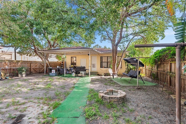 3622 W Mullen Ave, Tampa, FL 33609 - back of house with a fenced backyard, stucco siding, a fire pit, and a patio
