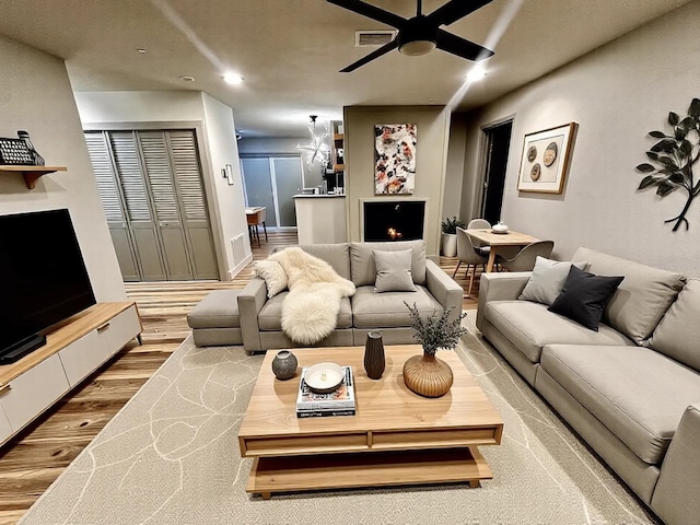 5950 Edison St, Cocoa, FL 32927 - living area featuring a warm lit fireplace, a ceiling fan, wood finished floors, and recessed lighting