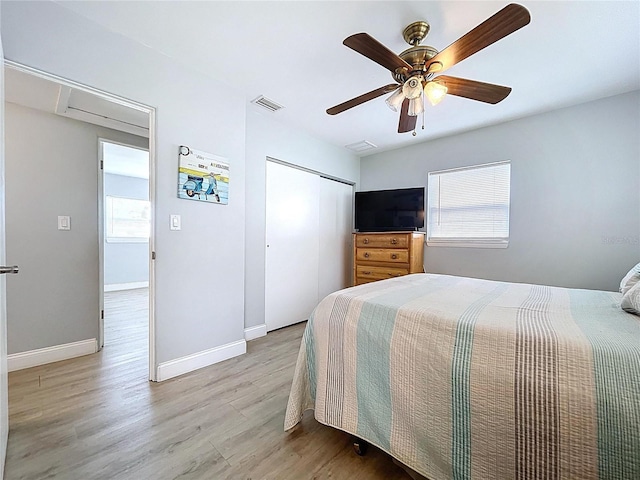 1445 Coburn Dr, Tarpon Springs, FL 34689 - bedroom with light wood-style floors, multiple windows, a closet, and a ceiling fan