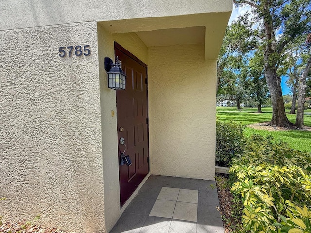 5785 Gardens Dr, Sarasota, FL 34243 - doorway to property featuring stucco siding