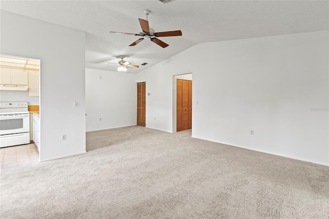 5785 Gardens Dr, Sarasota, FL 34243 - unfurnished living room featuring light colored carpet, vaulted ceiling, and a ceiling fan