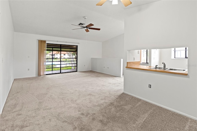 5785 Gardens Dr, Sarasota, FL 34243 - unfurnished living room featuring a ceiling fan, carpet floors, and high vaulted ceiling