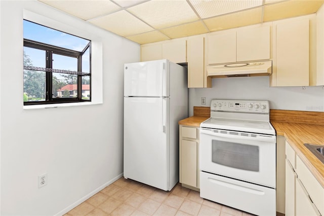 5785 Gardens Dr, Sarasota, FL 34243 - kitchen featuring white appliances, under cabinet range hood, light countertops, light flooring, and a drop ceiling