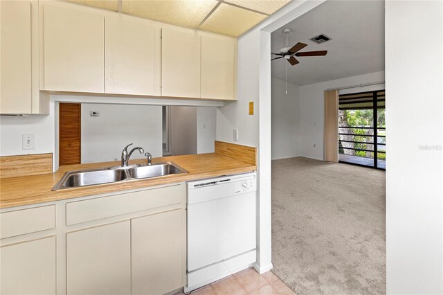 5785 Gardens Dr, Sarasota, FL 34243 - kitchen with white dishwasher, ceiling fan, light countertops, and light carpet