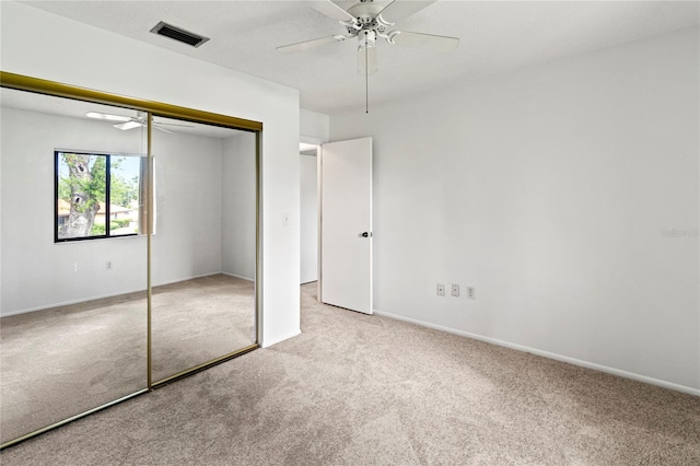 5785 Gardens Dr, Sarasota, FL 34243 - unfurnished bedroom with light carpet, a closet, and ceiling fan