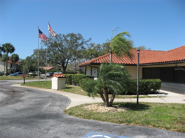5785 Gardens Dr, Sarasota, FL 34243 - view of side of home with a tiled roof and stucco siding