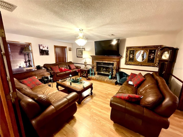 8834 Whispering Oaks Trl, New Port Richey, FL 34654 - living area featuring wood finished floors, a textured ceiling, and a fireplace