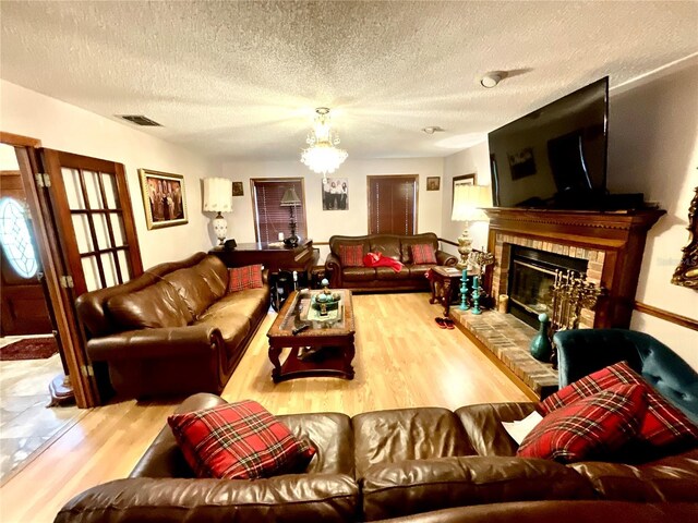 8834 Whispering Oaks Trl, New Port Richey, FL 34654 - living room with wood finished floors, a textured ceiling, and a glass covered fireplace