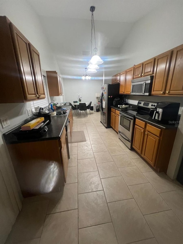 1421 Mohrlake Dr, Brandon, FL 33511 - kitchen featuring stainless steel appliances, dark countertops, brown cabinetry, light tile patterned floors, and a chandelier