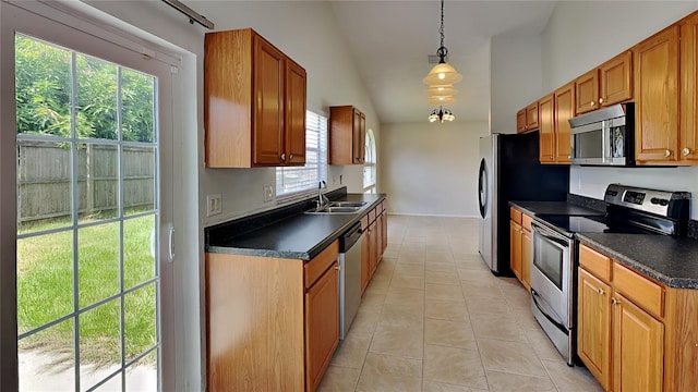 1421 Mohrlake Dr, Brandon, FL 33511 - kitchen with stainless steel appliances, dark countertops, light tile patterned floors, brown cabinets, and high vaulted ceiling