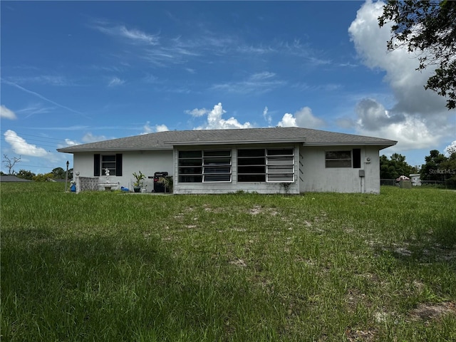 1106 Trellis Ave, Spring Hill, FL 34606 - back of house featuring stucco siding and a lawn