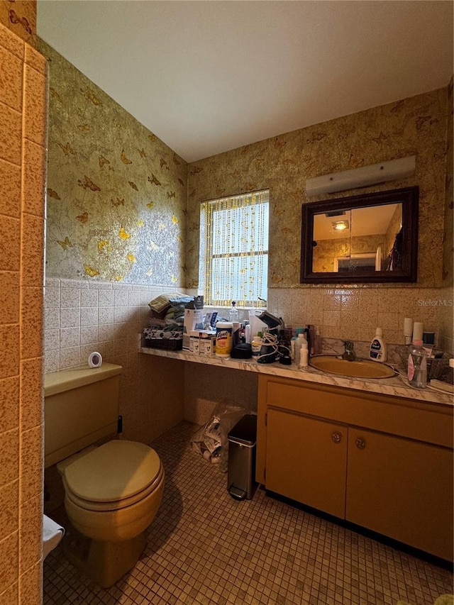1106 Trellis Ave, Spring Hill, FL 34606 - bathroom with tile walls, vanity, wainscoting, wallpapered walls, and tile patterned flooring