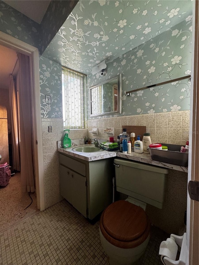 1106 Trellis Ave, Spring Hill, FL 34606 - bathroom with wallpapered walls, vanity, tile walls, and a wainscoted wall