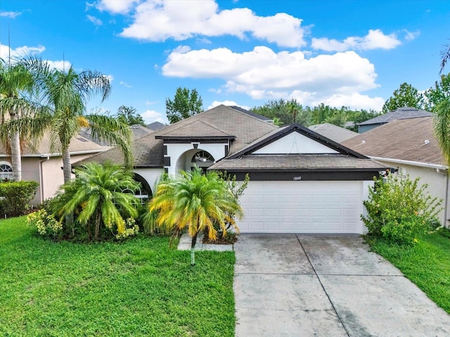 18419 Merseyside Loop, Land O Lakes, FL 34638 - ranch-style home with stucco siding, an attached garage, concrete driveway, a front yard, and a shingled roof