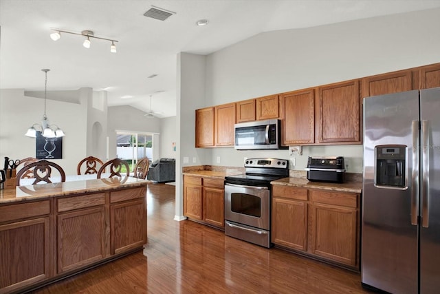 18419 Merseyside Loop, Land O Lakes, FL 34638 - kitchen with appliances with stainless steel finishes, vaulted ceiling, a chandelier, brown cabinetry, and dark wood-style flooring