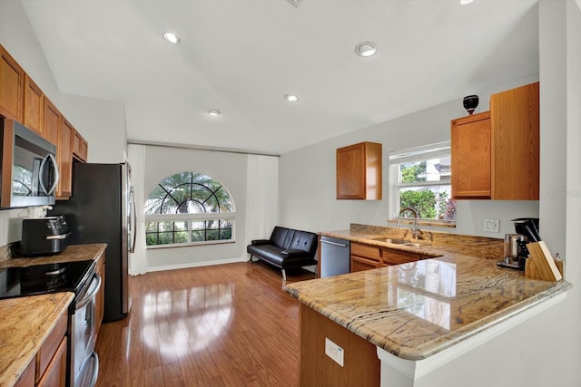 18419 Merseyside Loop, Land O Lakes, FL 34638 - kitchen with appliances with stainless steel finishes, brown cabinetry, light stone counters, wood finished floors, and recessed lighting