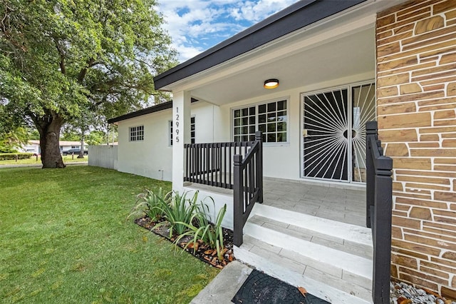 12995 NE 5th Ave, North Miami, FL 33161 - view of exterior entry featuring a lawn and a porch