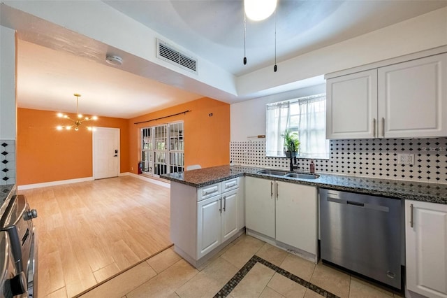 12995 NE 5th Ave, North Miami, FL 33161 - kitchen featuring dishwasher, a peninsula, white cabinets, tasteful backsplash, and decorative light fixtures