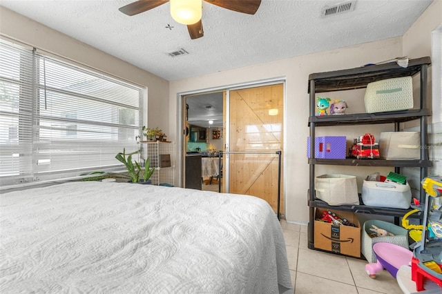 7441 Cypress Dr, New Port Richey, FL 34653 - bedroom featuring light tile patterned floors, ceiling fan, and a textured ceiling