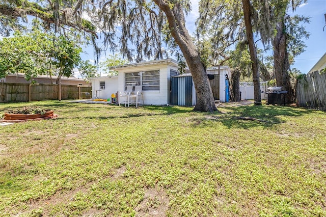 7441 Cypress Dr, New Port Richey, FL 34653 - rear view of house with a fenced backyard, concrete block siding, and a storage shed
