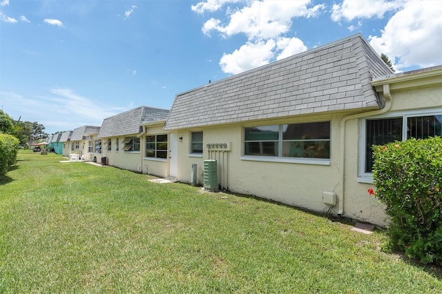 7000 Lafayette N, Pinellas Park, FL 33781 - rear view of house featuring mansard roof, roof with shingles, and stucco siding