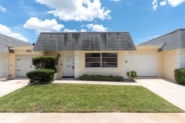 7000 Lafayette N, Pinellas Park, FL 33781 - view of front of property featuring an attached garage, driveway, mansard roof, and stucco siding