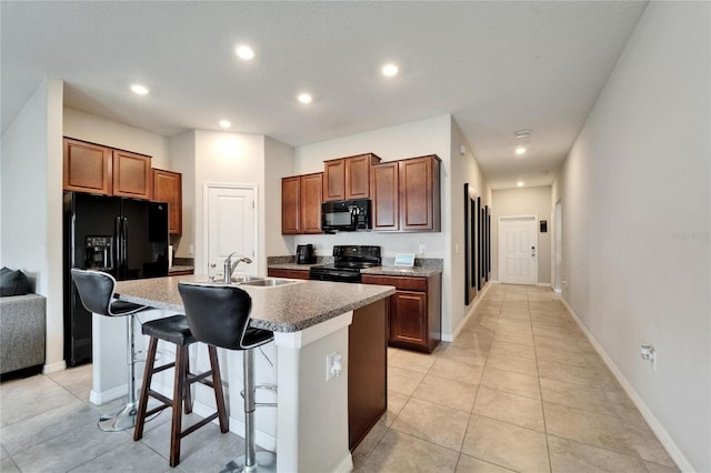 10119 Rose Petal Pl, Riverview, FL 33578 - kitchen featuring black appliances, a breakfast bar area, a center island with sink, light tile patterned floors, and recessed lighting