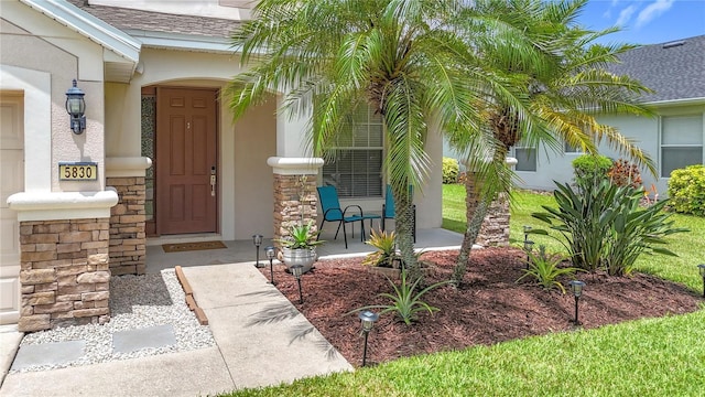 5830 100th Ave E, Parrish, FL 34219 - property entrance featuring stone siding, stucco siding, roof with shingles, and a porch