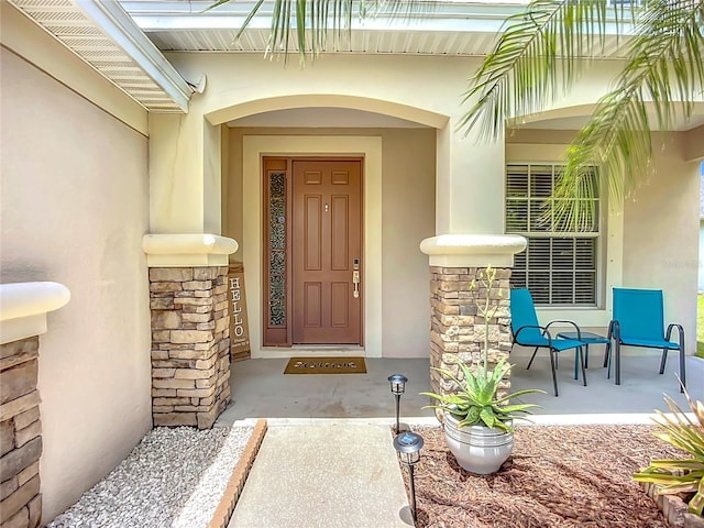 5830 100th Ave E, Parrish, FL 34219 - property entrance featuring stucco siding, stone siding, and a porch