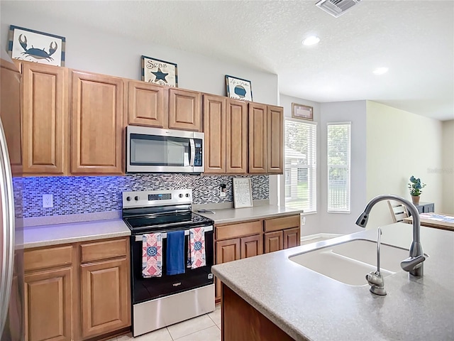 5830 100th Ave E, Parrish, FL 34219 - kitchen featuring appliances with stainless steel finishes, tasteful backsplash, a textured ceiling, light tile patterned floors, and recessed lighting