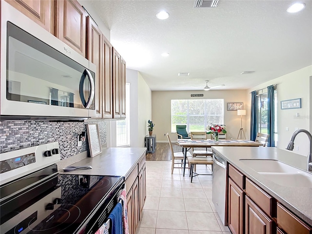 5830 100th Ave E, Parrish, FL 34219 - kitchen with appliances with stainless steel finishes, decorative backsplash, ceiling fan, recessed lighting, and light tile patterned floors