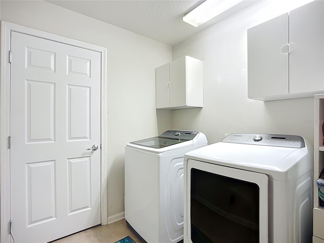 5830 100th Ave E, Parrish, FL 34219 - washroom featuring washer and clothes dryer, cabinet space, and light tile patterned flooring