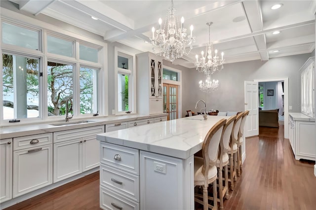 6220 Bayshore Blvd, Tampa, FL 33611 - kitchen with coffered ceiling, a chandelier, white cabinetry, a kitchen breakfast bar, and a kitchen island with sink