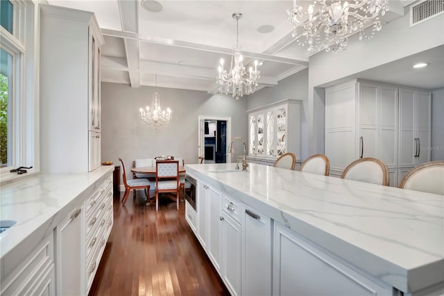 6220 Bayshore Blvd, Tampa, FL 33611 - kitchen featuring a chandelier, coffered ceiling, beam ceiling, dark wood finished floors, and light stone countertops