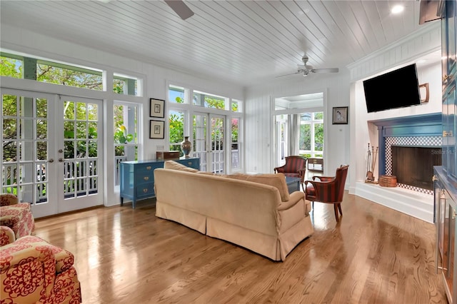 6220 Bayshore Blvd, Tampa, FL 33611 - living area with french doors, ceiling fan, a fireplace with raised hearth, light wood-type flooring, and crown molding