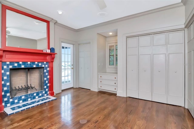 6220 Bayshore Blvd, Tampa, FL 33611 - unfurnished living room featuring ornamental molding, wood finished floors, a tiled fireplace, a ceiling fan, and recessed lighting