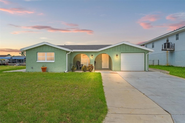 7401 Islander Ln, Hudson, FL 34667 - view of front of home with a garage, a front yard, concrete driveway, stucco siding, and cooling unit