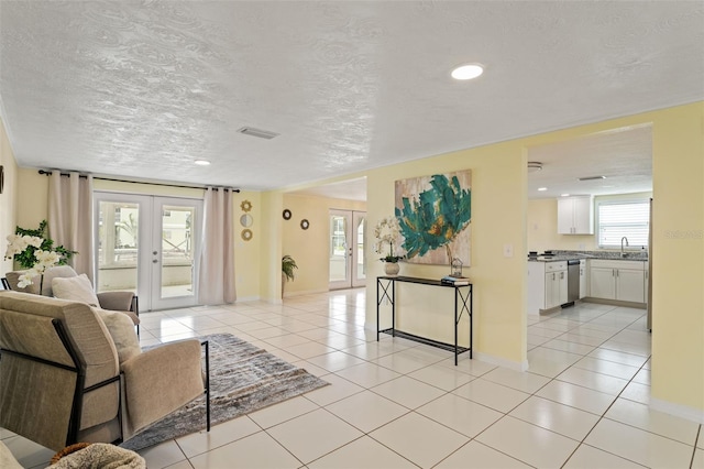 7401 Islander Ln, Hudson, FL 34667 - living room featuring french doors, light tile patterned floors, a textured ceiling, and recessed lighting